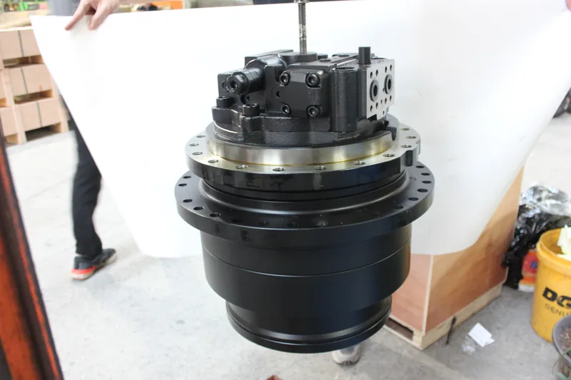 Black travel motor and final drive assembly photographed in a workshop
