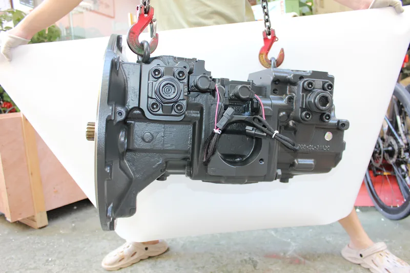 Large hydraulic pump assembly handled in a supplier workshop