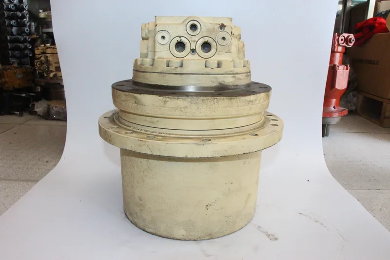 Used travel motor and final drive assembly on a workshop backdrop